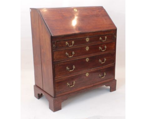 A George III provincial oak bureau - late-18th century, the nicely-figured fall front enclosing a fitted interior with six dr