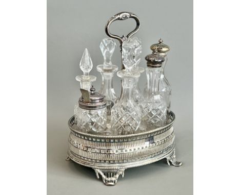 A silver plated and cut glass cruet stand, c.1900 - pierced oval form in the Georgian taste, with foliate capped top handle a