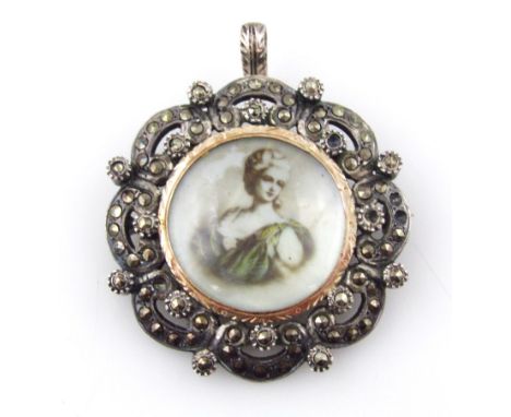 A silver pendant/brooch, with central half portrait, with marcasite set borders, in a floral scroll, 3.5cm wide. 