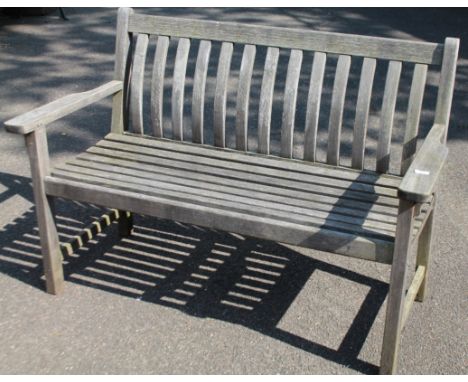 A 20thC slatted garden bench, with shaped back, plain seat and square block supports joined by back to front stretchers, 88cm