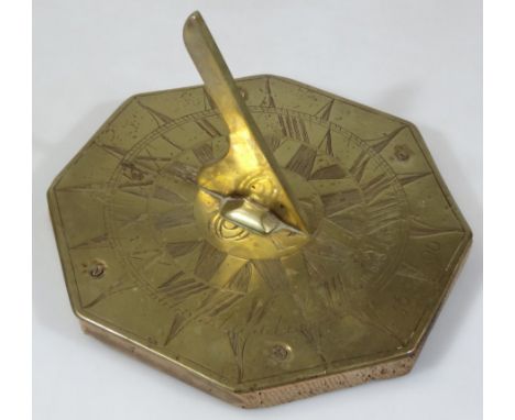 A reproduction brass sundial, of octagonal outline set with sun and central arch, bearing date 1690, and named Lux, 20cm wide