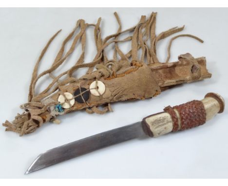 A 20thC native American hunting knife, with horn style handle, elaborate leather part buttoned scabbard and plain blade, 36cm