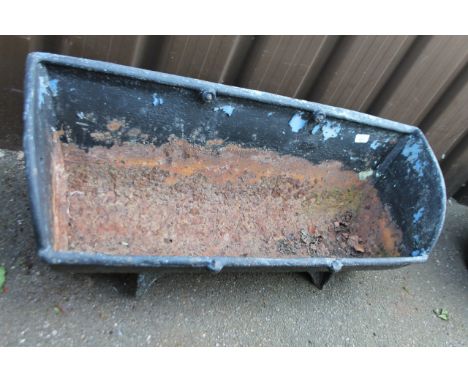 A 20thC metal animal feeding trough, painted black, 94cm wide.
