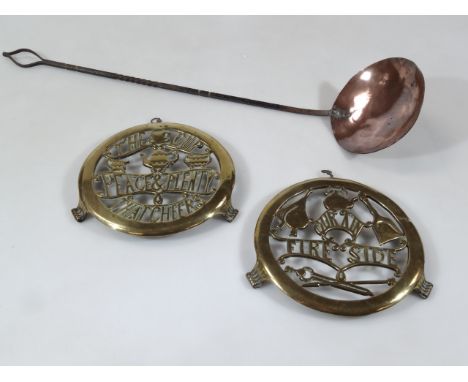 Two AGA style brass plates, with compressed scroll feet, 18cm wide, and a copper and iron handle serving ladle. (3)