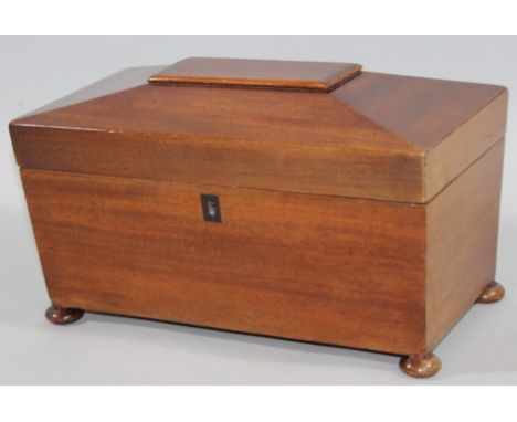 A 19thC mahogany tea caddy, of rectangular sarcophagus outline, the hinged lid revealing a fitted interior with mixing bowl f