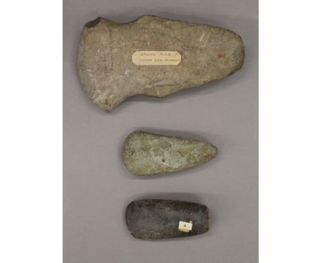 Three stone axe heads. The largest 18 cm long.