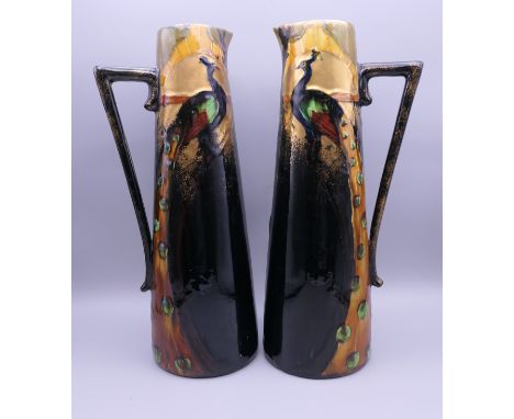 A pair of Frederick Rhead Art Nouveau pottery ewers. 30.5 cm high; 10.5 cm diameter.