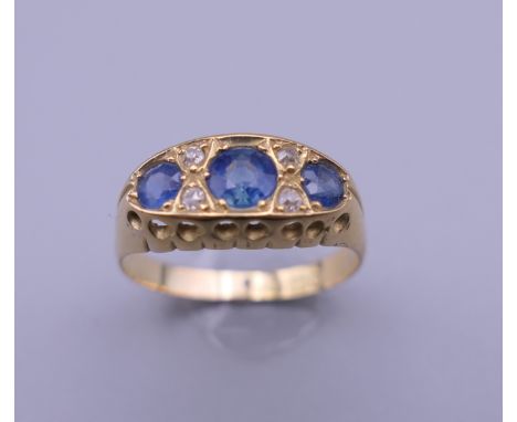 An 18 ct gold diamond and sapphire ring. Ring size Q/R. 3 grammes total weight.