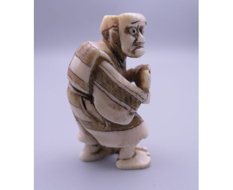 A 19th century Japanese ivory netsuke of a masked man. 5 cm high.