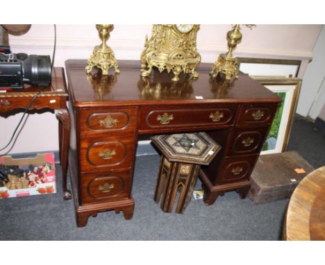 c.1900, the plain top with thumb moulded rim, above a single frieze drawer, flanked by six small drawers, raised on ogee brac