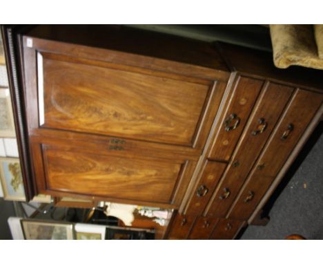 the upper section enclosed by pair of panel doors opening to reveal a shelved interior seated on a chest of two short and two