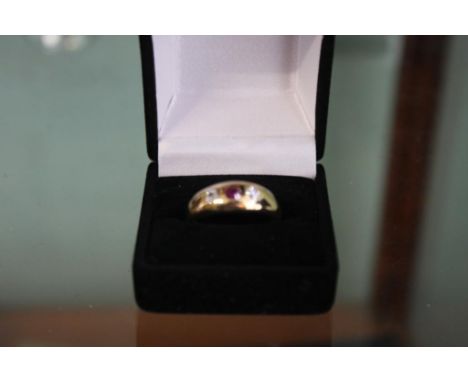 the three stone ring with the central garnet flanked by two diamonds in an 18CT yellow gold band