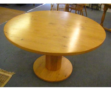 A Stuart Linford light oak circular topped dining table on a column support and circular base, retail price £5,500, 49 diamet