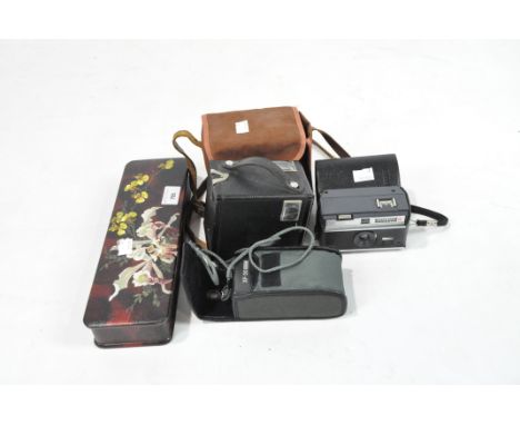 A glove box and three cameras, the first painted withh flowers, the cameras including a Brownie Six-20 Model C, and Instamati