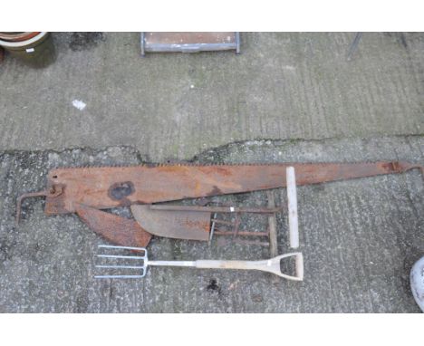 A large vintage two-person saw and two peat cutters, a fork, and more tools