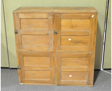 A pine panelled cupboard, late 19th/early 20th century with four doors, three with brass fittings, each enclosing a shelf, 10