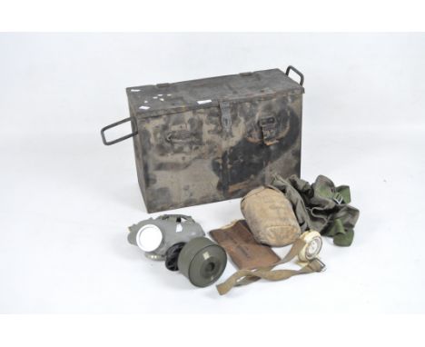 A military gas mask and other military related items, including a bag and water bottle, all in a metal ammunition case, dated