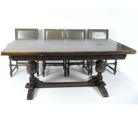 An early 20th century extendable wooden refectory table, raised on leaf carved cup and cover supports, united by a straight s