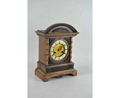 A Continental oak striking mantle clock, early 20th century, with arched pediment, with ivorine chapter ring with black Roman