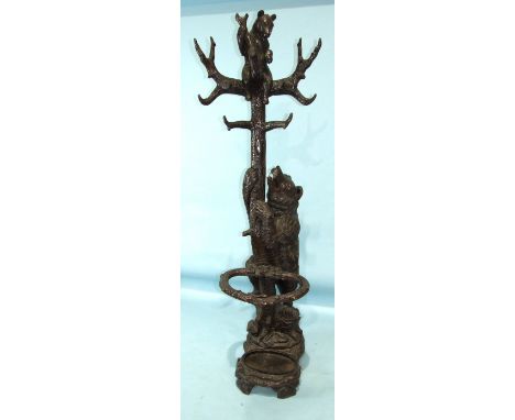 A late-19th/early-20th century Black Forest carved wood hall stand in the form of a large carved bear and tree with a bear cu