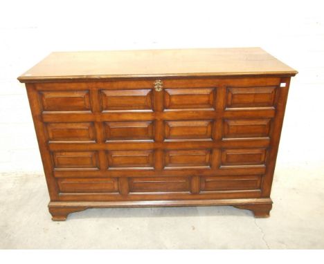 A large oak hall chest constructed of fielded panels, raised on shaped bracket feet, 143cm wide, 96cm high, 61cm deep.
