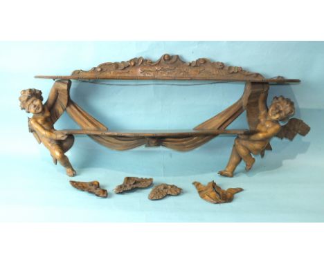 A 19th century Continental soft wood wall shelf bracket, the two shaped shelves supported at each end by a winged cherub, 95c