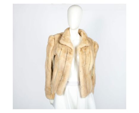 A custom design beige fur coat with grey leather trimming and silk interior. With pockets. J.S.R. patch sewing to interior. C