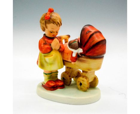 Porcelain figurine of a little girl in prayer pose along side a toy baby carriage. Hand painted item with matte finish. Round