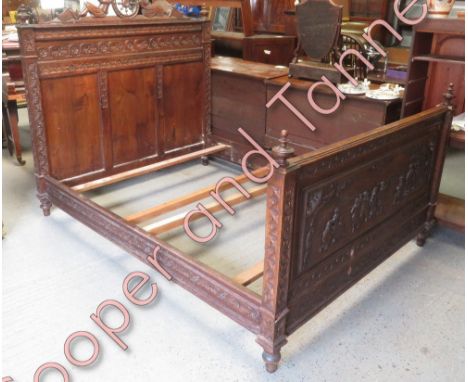 A Continental carved oak double bed, the foot board worked with figures dancing, drinking from a barrel and playing musical i