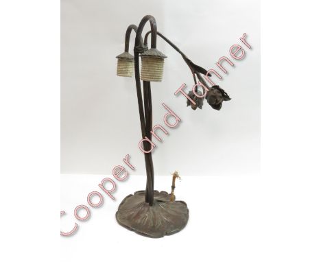 An American cast metal table lamp with decorative flower heads, down turned lamps holders on reeded pedestal and cast lilly p