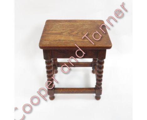 An oak joint stool the rectangular top on four bobbin turned supports and plain stretchers 49cms high