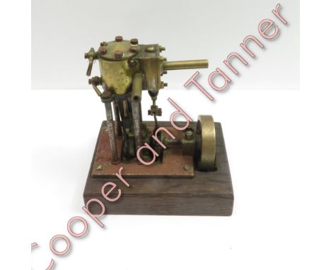 A small engineered brass working model of a single cylinder pump engine mounted on a wood base, 13cms high