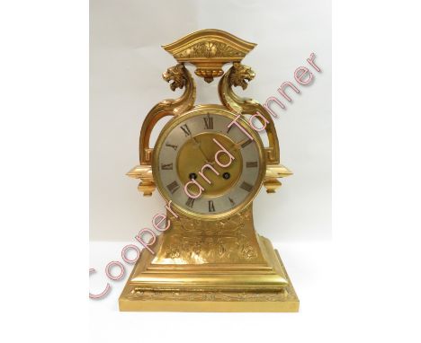 A large open face late 19th century brass case 8 day French mantel clock. Silvered chapter ring with ornate brass hands and g