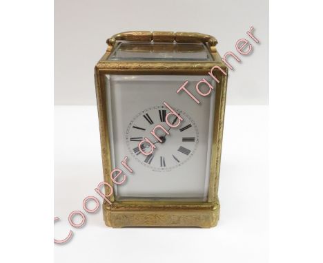 An ornate engraved gilt brass 2 train 8 day carriage clock, striking on bell. The white enamel dial signed Bolviller A Paris,