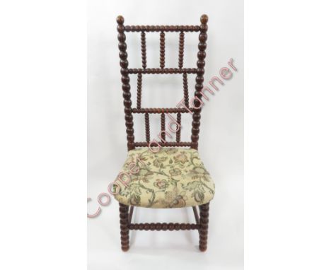 A stained beech nursing chair with bobbin turned frame and upholstered seat