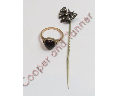 An unmarked cabochon garnet set ring, finger size M, 3.5 g gross; with a paste set butterfly stickpin