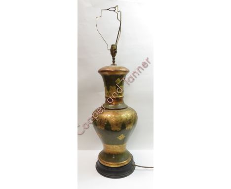 A large decorative table lamp of baluster form with incised decoration and large brown shade height of lamp base 46cms high