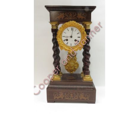 A 19th century French 'Portico' style 8 day mantle clock, enamel dial with decorative gilded bezel and pendulum; bell strike 