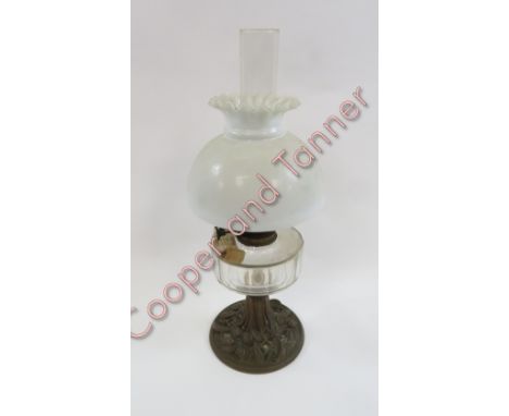 A late 19th/early 20th Century oil lamp with white glass shade, Duplex burner, faceted glass reservoir and decorative brass b