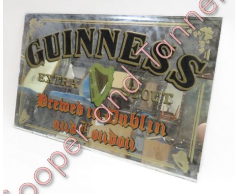 A Guinness advertising wall mirror, with gilt, black and coloured lettering and shamrock and harp detail, 56cms x 87cms