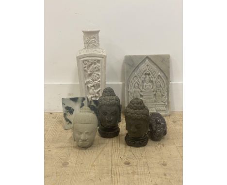 A grouping of Asian carved stone items, including three Buddha heads, two seared Buddhas, a white marble carved panel and two