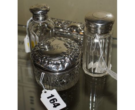 Cut glass circular and one oblong trinket box with silver lids and two glass bottles with silver lids early 1900s