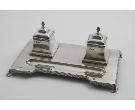 AN EARLY 20TH CENTURY INKSTAND  on a shaped rectangular base with bracket feet, reed and ribbon borders and two receivers wit