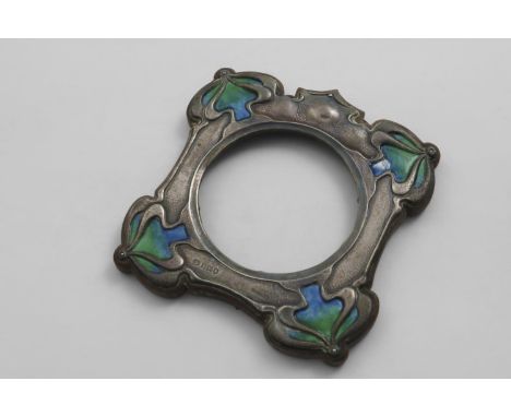 THE FRONT OF AN EDWARDIAN ART NOUVEAU MOUNTED WOODEN PHOTOGRAPH FRAME with enamelled decoration in the corners and a hammered