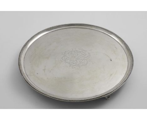 A GEORGE III CIRCULAR SALVER with a bead border, three beaded bracket feet, engraved in the centre with script, foliate initi
