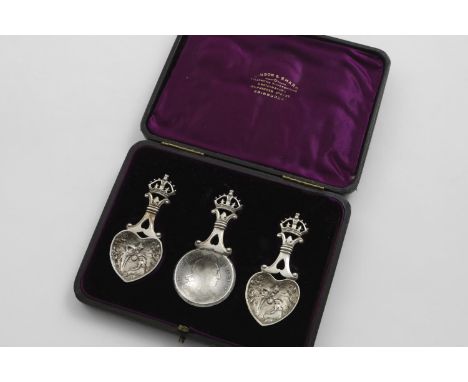 AN UNUSUAL CASED SET OF THREE CADDY SPOONS each with an openwork, Royal Crown finial; one with a coin bowl (a William III cro