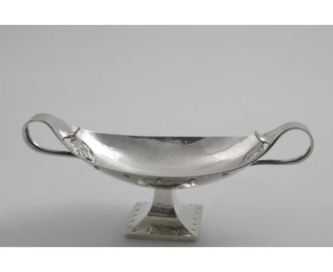 AN EARLY 20TH CENTURY ARTS AND CRAFTS TWO-HANDLED BONBON DISH brat-shaped with a square pedestal foot, applied and punched be