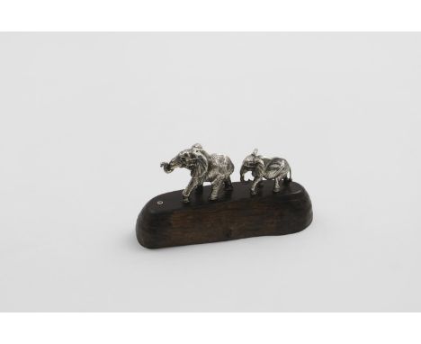 BY PATRICK MAVROS OF ZIMBABWE:- A late 20th cenutry small cast figure group of two elephants walking in a line, larger one fi