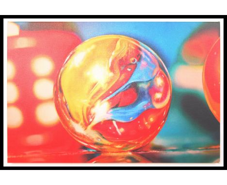 A contemporary graphic art print depicting a rolling glass marble with bold colours. The print set to canvas and stretched ar