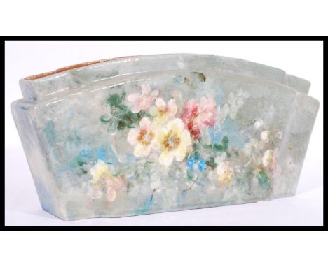 A 20th century studio art pottery ceramic flower vase of lozenge form being handpainted with floral sprays and cloudy grey gr